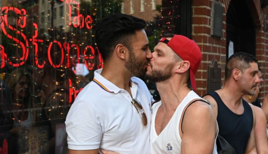 People kiss as they gather for the 50th anniversary of the Stonewall Riots in front of the Stonewall Inn in New York, June 28, 2019.