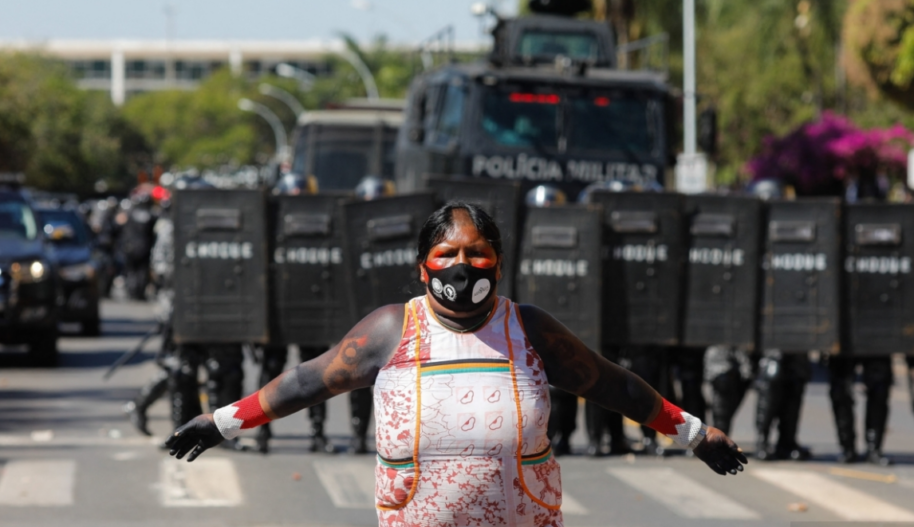 Indigenous woman in protest in front of riot police