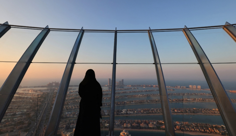 A woman stands at "the View at Palm" overlooking the Palm Jumeirah in the Gulf emirate of Dubai on January 10, 2022. (Photo by Giuseppe CACACE / AFP by Getty Images)