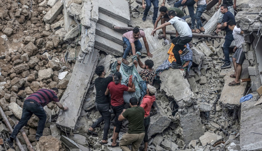GAZA CITY, GAZA - OCTOBER 20: People carry a dead body pulled from rubble as civil defense teams and residents continue search and rescue efforts in the historical Greek Orthodox Saint Porphyrius Church, where civilians took shelter, after Israeli airstrike in Gaza City, Gaza on October 20, 2023. At least eight people were killed in an overnight Israeli airstrike on the Greek Orthodox Saint Porphyrius Church in Gaza city, which was sheltering hundreds of Palestinians, local media reported on Friday. (Photo by Ali Jadallah/Anadolu via Getty Images)