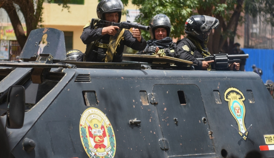 security forces point weapons from an armoured vehicle