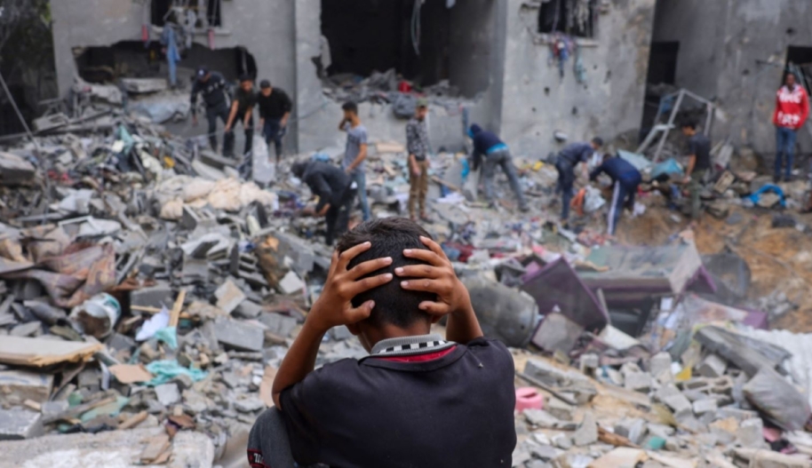 A child reacts as people salvage belongings amid the rubble of a damaged building following strikes on Rafah in the southern Gaza Strip, on November 12, 2023, as battles between Israel and the Palestinian Hamas movement continue. Photo by MOHAMMED ABED/AFP via Getty Images.