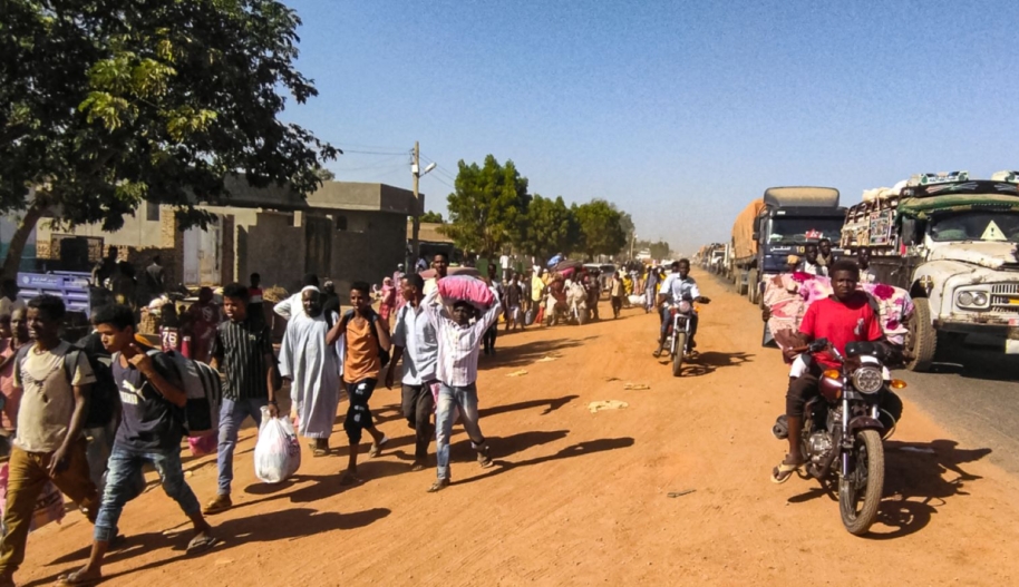People displaced by the conflict in Sudan walk with their belonging along a road in Wad Madani, the capital of al-Jazirah state, on December 16, 2023. Fighting between the Sudanese army and paramilitaries engulfed the aid hub of Wad Madani on December 15, triggering an exodus of civilians already displaced by eight months of war, an AFP correspondent reported. Photo by AFP via Getty Images