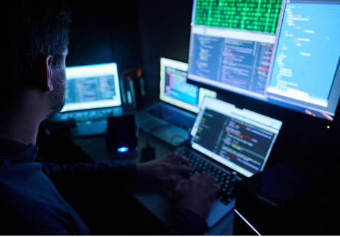 12 February 2023, Berlin: Illustration: Fictitious html pages and hacker programs are seen on screens while a man has his hands on the keyboard. Photo: Annette Riedl/dpa (Photo by Annette Riedl/picture alliance via Getty Images)