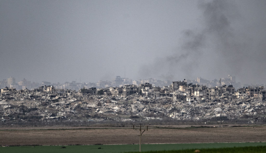 Smoke rises from the rubble of buildings that have been destroyed in military airstrikes