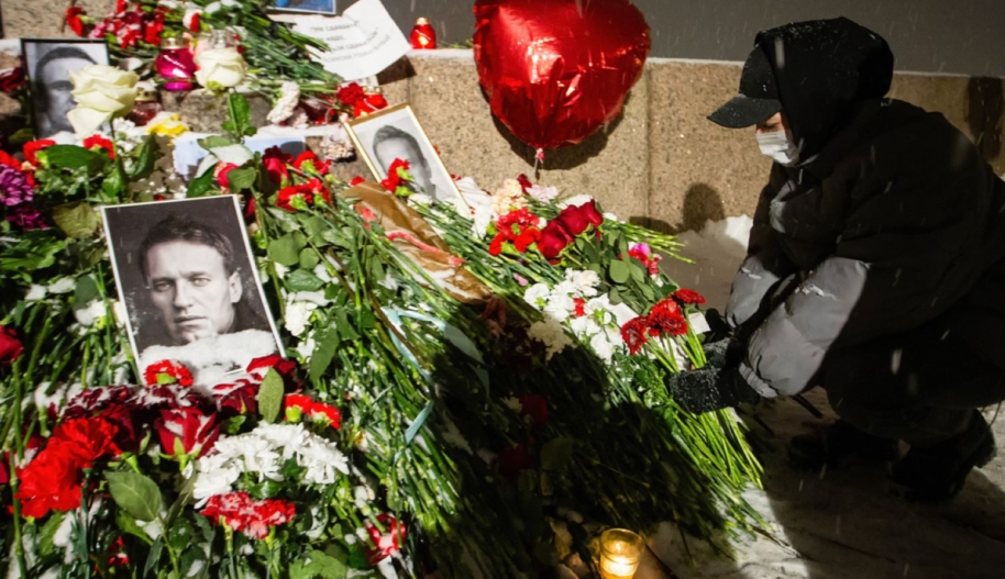 A mourner lays flowers at a spontaneous memorial in memory of the deceased Russian opposition leader Alexei Navalny, organized at the monument to victims of political repression on Voskresenskaya Embankment on 16 Feb 2024. Photo by Artem Priakhin/SOPA Images/LightRocket via Getty Images